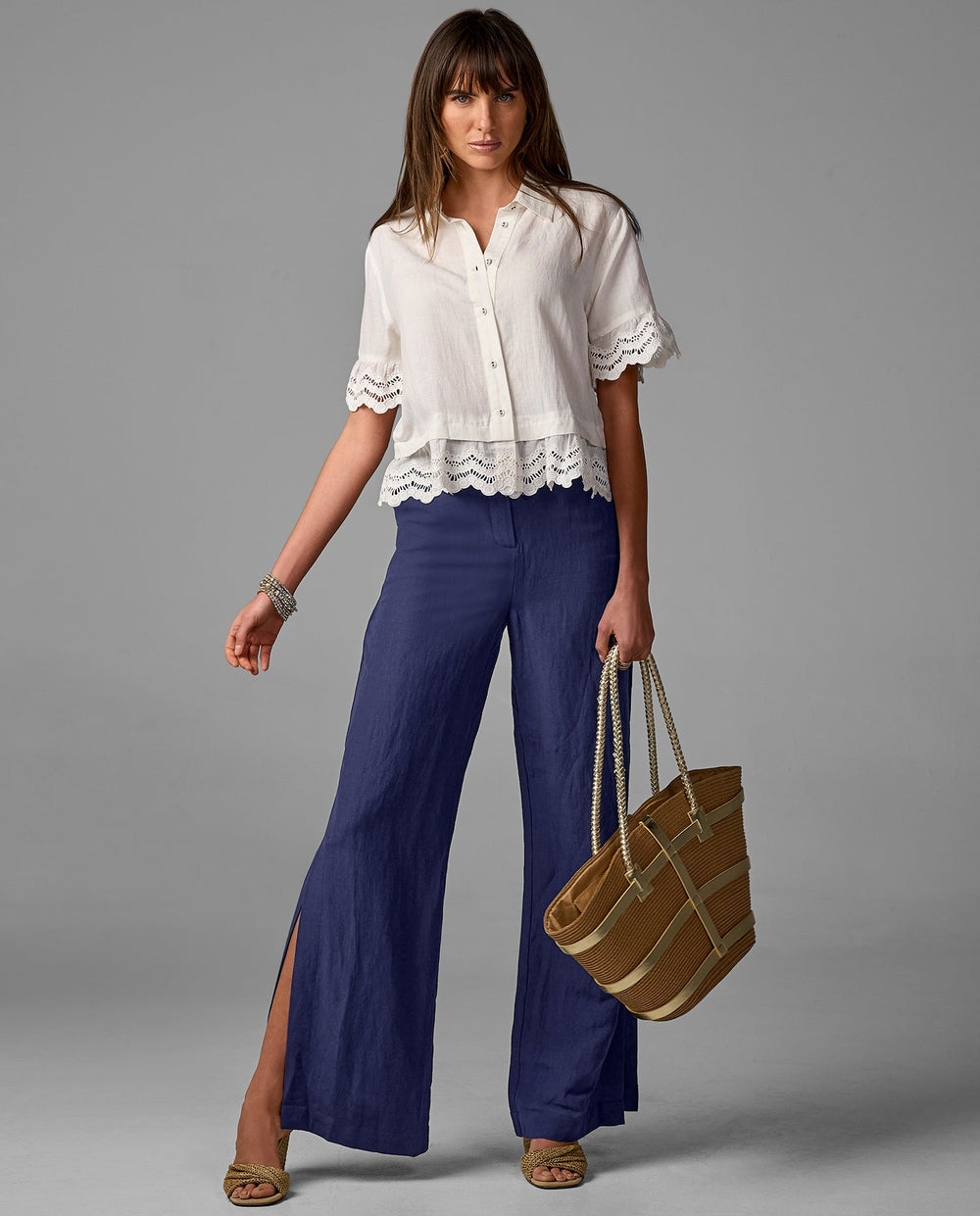 Model is wearing white top with dark blue pant